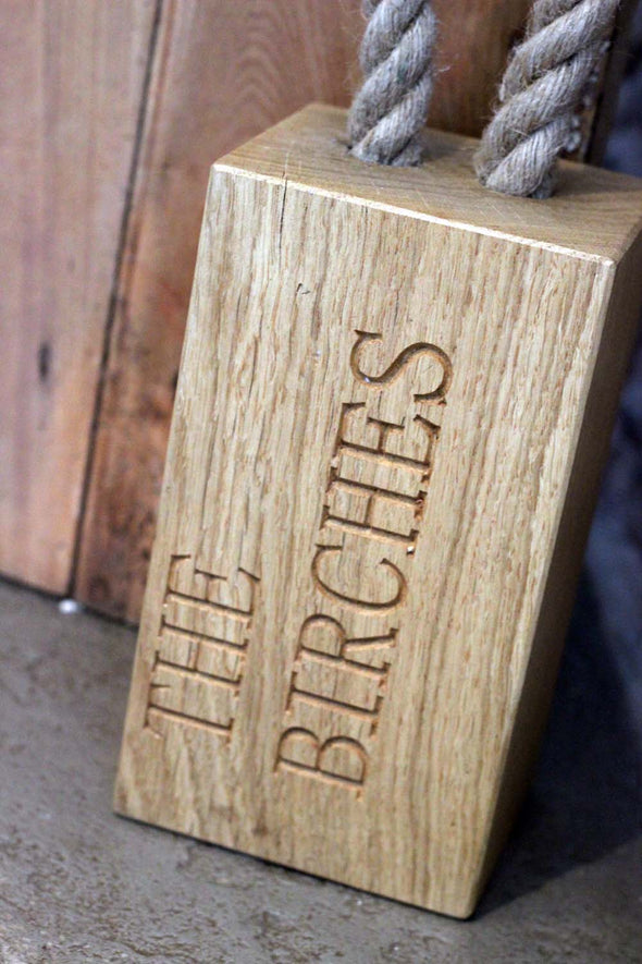 personalised oak door stop with rope handle.