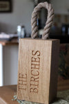 personalised oak door stop with rope handle.